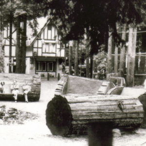 A Dog and His Humans Sitting on Old Growth Redwood Benches in Front of the Rio Nido Lodge