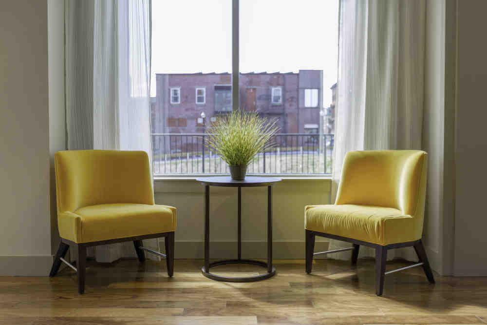 sitting area with yellow chairs and round accent table